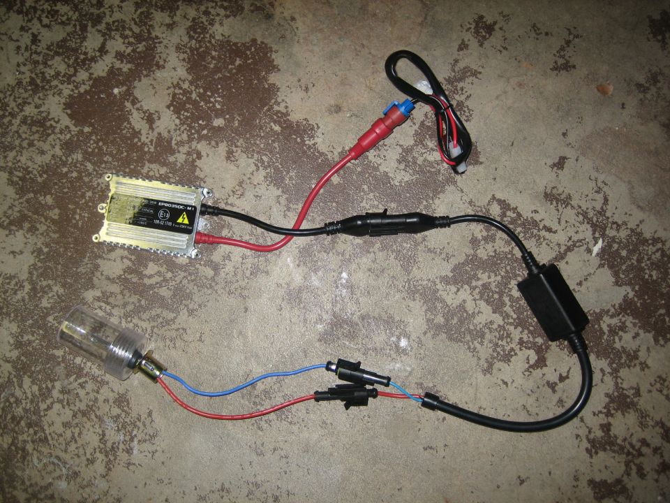 HID ballast and bulb assembly with wiring laid out on concrete floor
