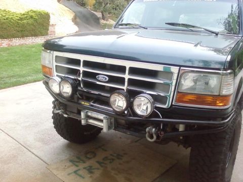 1995 Ford Bronco - Front view of a green Ford Bronco with off-road modifications.