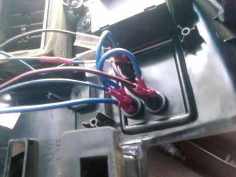 1995 Ford Bronco - A close-up view shows a wiring harness with blue and red wires connected to electrical terminals, likely part of a vehicle's interior elect…