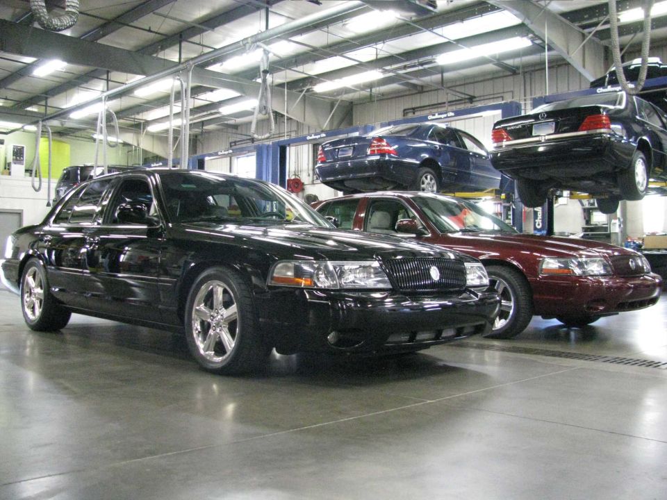 Black Mercury Marauder in a garage with other cars.
