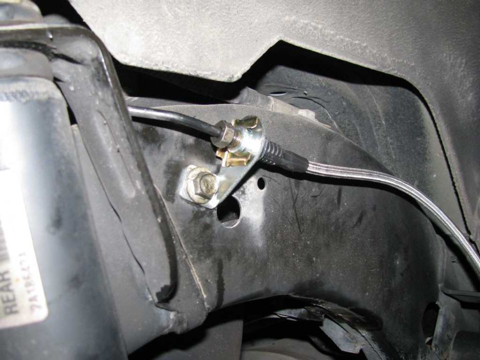 Braided steel brake line attached to vehicle frame with bracket