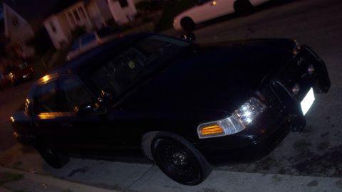2000 Ford Crown Victoria - Front view of a dark-colored car, details unclear due to lighting.