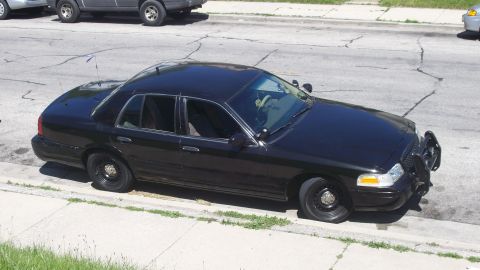 2000 Ford Crown Victoria - A dark blue sedan is captured from a 3/4 front angle on a paved surface.