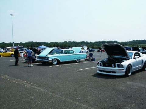 2001 Mercury Grand Marquis - Vehicles gathered at an outdoor car show, with people milling around.