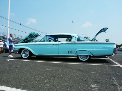 2001 Mercury Grand Marquis - A classic light blue Mercury sedan is displayed with its hood and trunk open at a car show.
