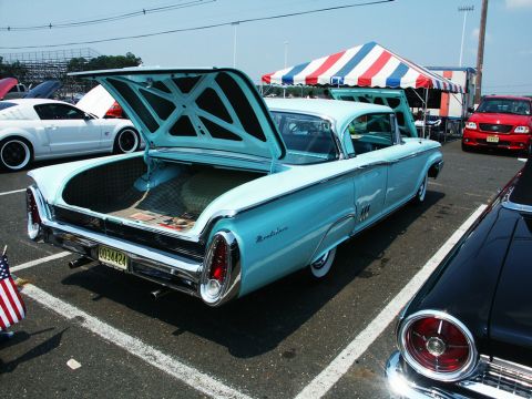 2001 Mercury Grand Marquis - A light blue 1959 Mercury Montclair is displayed with its trunk open at a car show, alongside other vehicles.