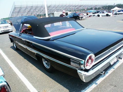 2001 Mercury Grand Marquis - A classic black convertible is displayed at a car show, with spectators and other vehicles visible in the background.