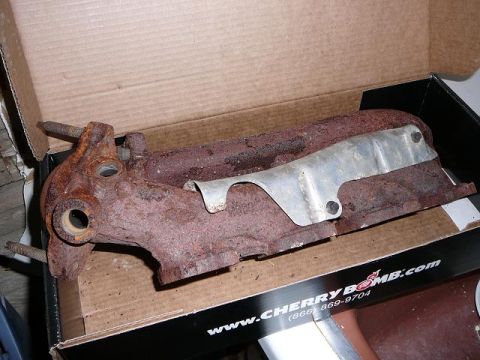 1997 Mercury Grand Marquis - This rusty exhaust manifold is shown in its packaging, which features Cherry Bomb branding and Supermotors.net.