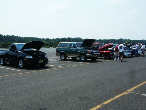 2001 Mercury Grand Marquis - Photo of a Lightning, Bronco, and other Ford trucks with hoods open at a car show.