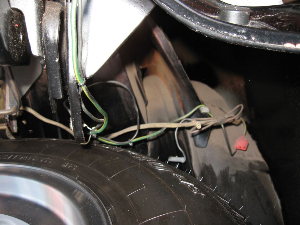 Close-up of vehicle wiring harness and a tire in the trunk area