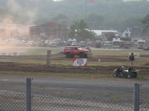 1984 Ford Bronco - Red lifted 1984 Ford Bronco participating in an event on a dirt track.