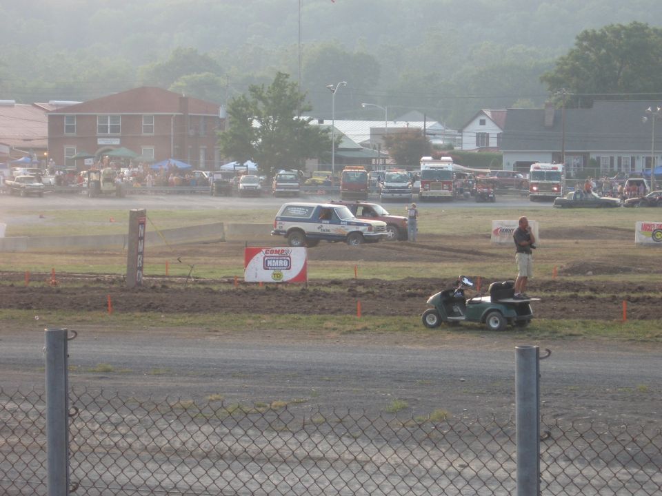 Blue and white 1984 Ford Bronco with racing decals on a dirt track