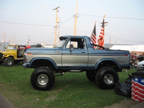 1984 Ford Bronco - This lifted blue and silver Ford Bronco, likely a 1978 model, is displayed with American flags.
