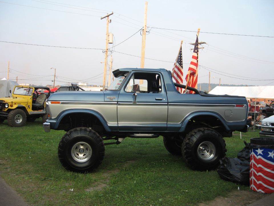 Lifted blue and silver 1978 Ford Bronco with American flags