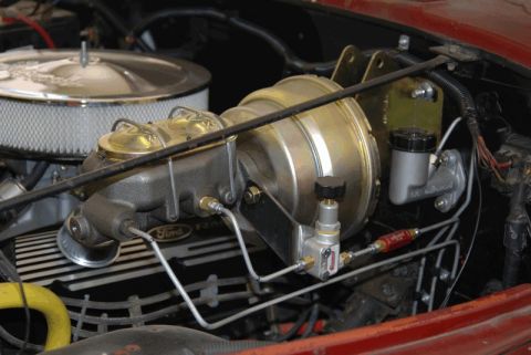 1975 Jeep CJ5 - Close-up of the brake booster and master cylinder assembly, with a Ford Racing valve cover visible.