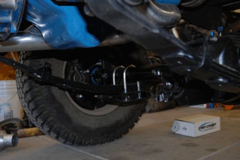 1975 Jeep CJ5 - Close-up of the rear axle and suspension components on a 1975 Jeep CJ5, with a Pro Comp parts box nearby.