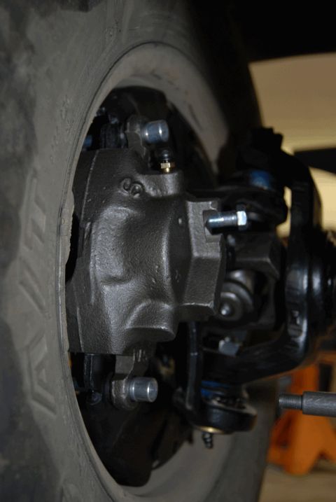 1975 Jeep CJ5 - Brake caliper and suspension components are visible next to the tire of a Jeep CJ.