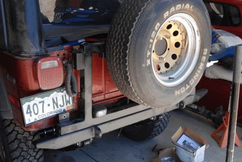 1975 Jeep CJ5 - Rear view of a red Jeep CJ5, showing a spare tire mounted on a custom bumper and a Colorado license plate.