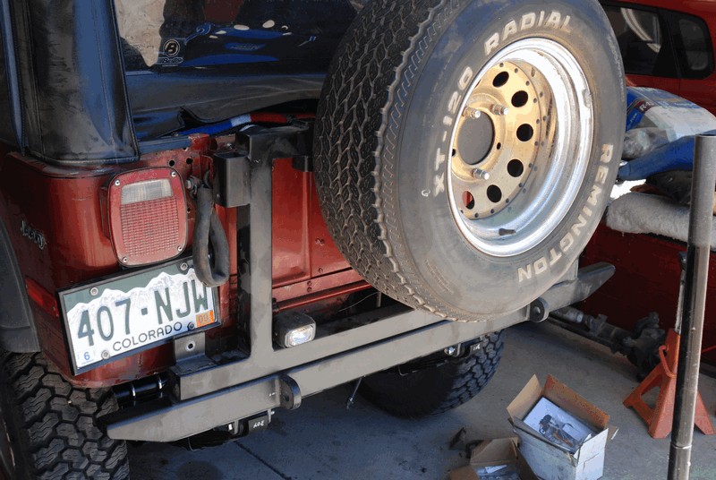 Red Jeep CJ5 rear with spare tire mounted on custom bumper, Colorado license plate 407-NJW