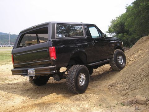 1995 Ford Bronco - 1995 Ford Bronco navigating an off-road trail.