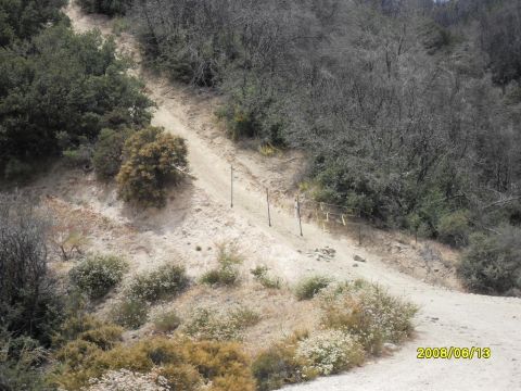 1990 Ford Bronco - A dirt road ascends a dry, brush-covered hillside under a clear sky.