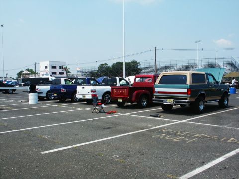 2001 Mercury Grand Marquis - A two-tone Ford Bronco is parked in a lot with other vehicles, including several Ford trucks.