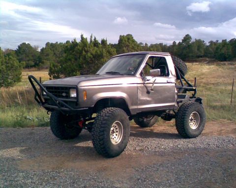 1984 Ford Bronco II - This modified 1983 Ford Bronco II features a custom bumper and roll cage, indicating off-road use.