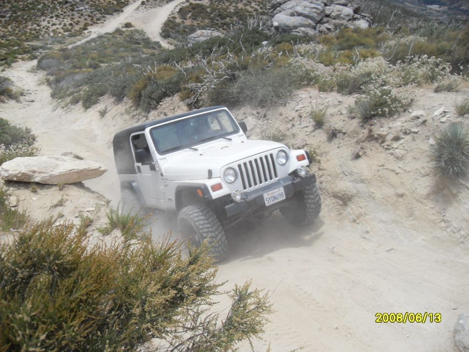White Jeep Wrangler on a dusty trail