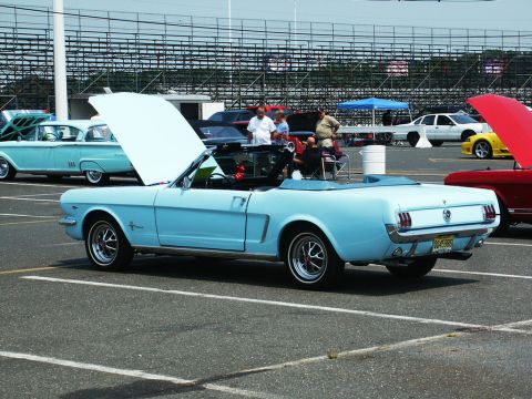 2001 Mercury Grand Marquis - A light blue 1965 Ford Mustang convertible is displayed with its hood open at a car show.