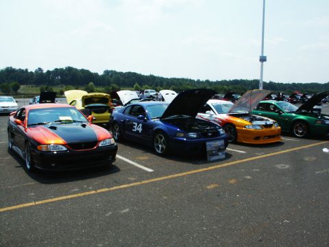 2001 Mercury Grand Marquis - Several cars are parked in a lot with their hoods open at a car show.
