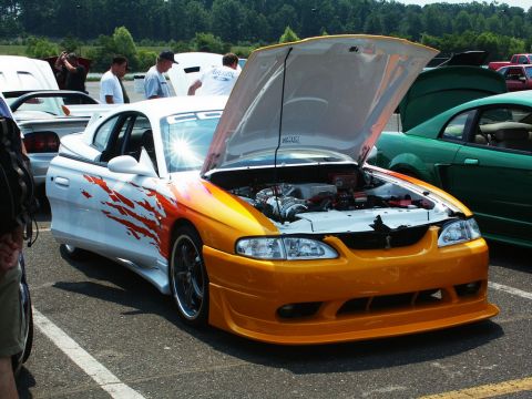 2001 Mercury Grand Marquis - A customized Ford Mustang is displayed with its hood open at an outdoor car show.