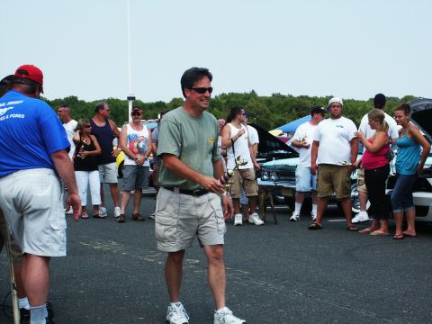 2001 Mercury Grand Marquis - Attendees mill about at a car show, with several vehicles on display and their hoods open.