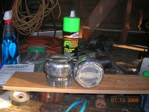 1985 Ford Bronco - A pair of locking hubs and a can of Turtle Wax F2 Tire Foam & Shine sit on a wooden shelf, with various tools and supplies in the backgroun…