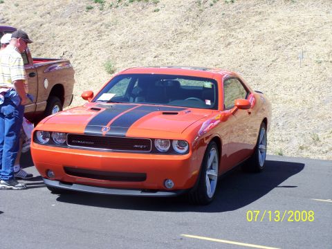 1972 Ford Ranchero - 2008 Dodge Challenger SRT8 with racing stripes, seen at an outdoor event.