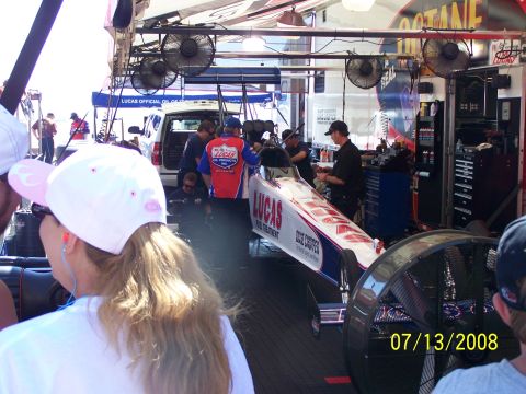 1972 Ford Ranchero - A dragster is worked on in a pit area, with fans and crew members visible.