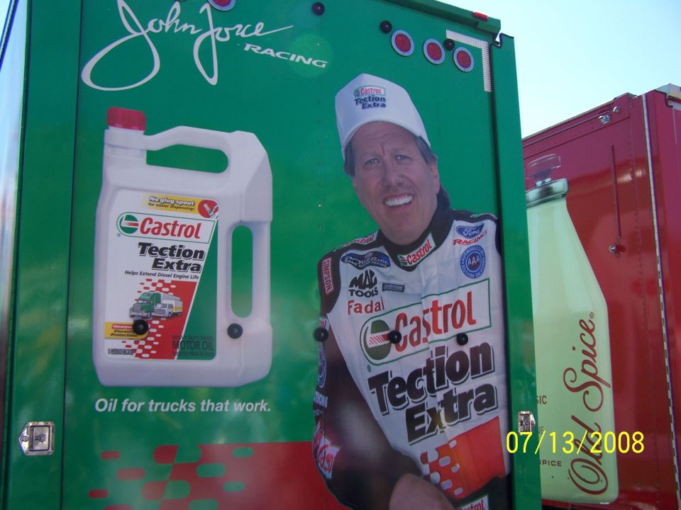 Green racing truck side with John Force graphic and Castrol Taction Extra ad