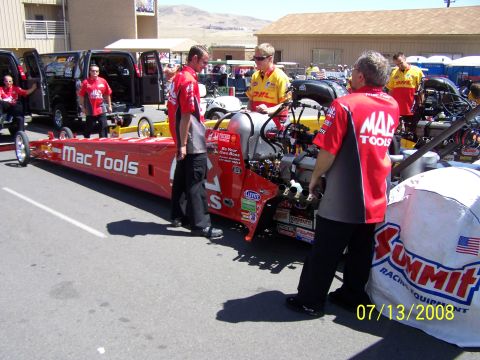 1972 Ford Ranchero - A dragster is prepared for a race, with crew members in matching shirts and support vehicles nearby.