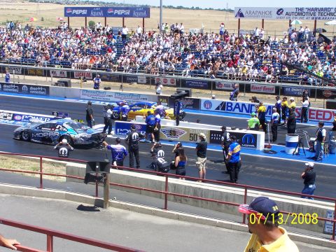 1972 Ford Ranchero - Drag racing event at Bandimere Speedway with spectators and two competing vehicles on the track.