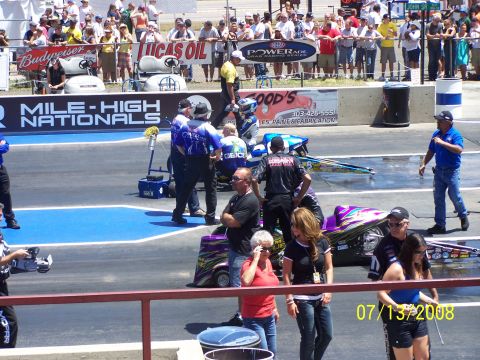 1972 Ford Ranchero - Spectators watch as crew members prepare dragsters on the track at a racing event.