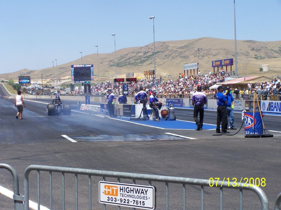 Drag racing scene with a dragster on the track and spectators in the stands on 07/13/2008