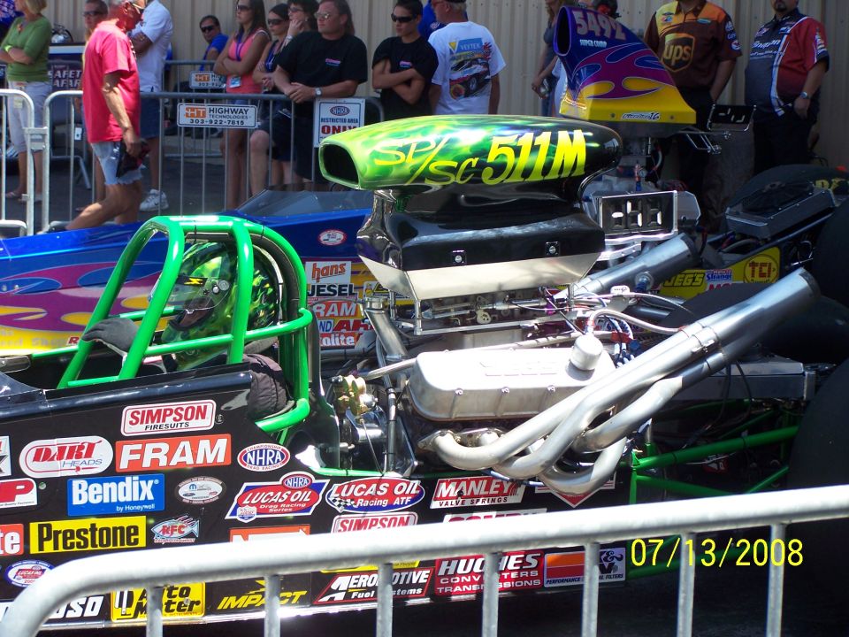 drag car engine with green roll cage and "SP/SC 511M" on the blower scoop. Many sponsor decals on the side