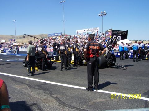 1972 Ford Ranchero - A drag racing car is prepared on the track with spectators in the background.