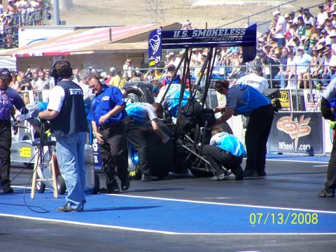 1972 Ford Ranchero - A drag racing car is being worked on by its crew on the track, with spectators in the background.