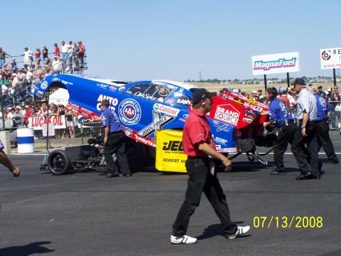 1972 Ford Ranchero - A drag racing car is prepared on the track, with crew members and spectators in the background.