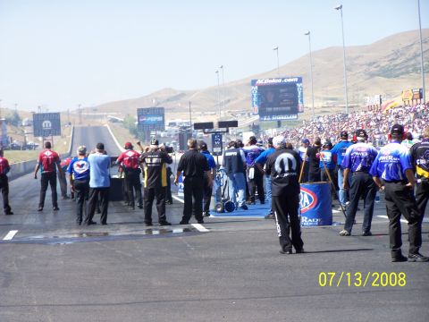 1972 Ford Ranchero - A drag racing event is underway with spectators filling the stands and officials on the track.