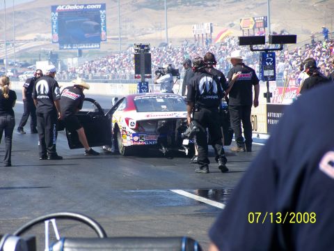 1972 Ford Ranchero - A drag racing car is prepped by its crew on the track, with spectators in the background.