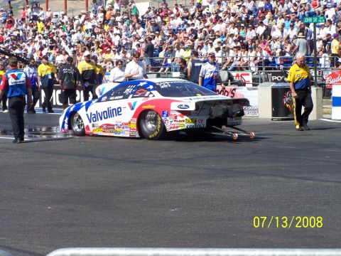 1972 Ford Ranchero - A drag racing car with Valvoline livery is on the track, with spectators in the stands.