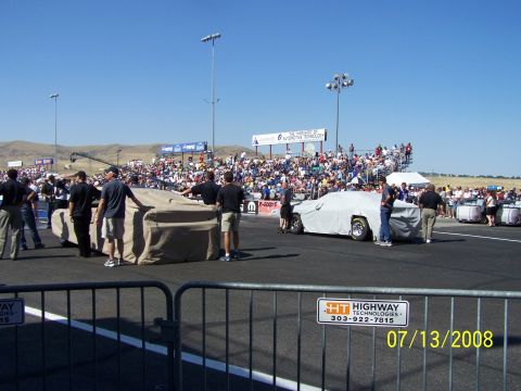 1972 Ford Ranchero - Covered vehicles at a drag racing event with a large crowd in the stands.
