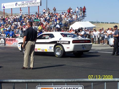 1972 Ford Ranchero - A white Dodge Challenger SRT drag car is on the track with spectators in the background.