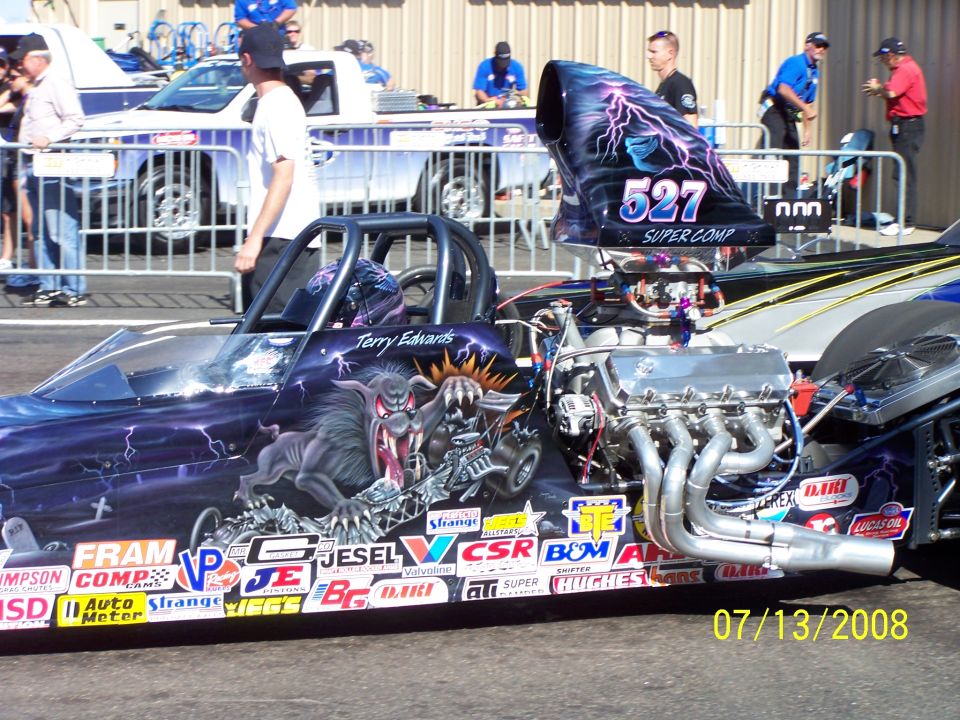 Dragster side view with custom monster graphics and "527 SUPER COMP" on the air intake